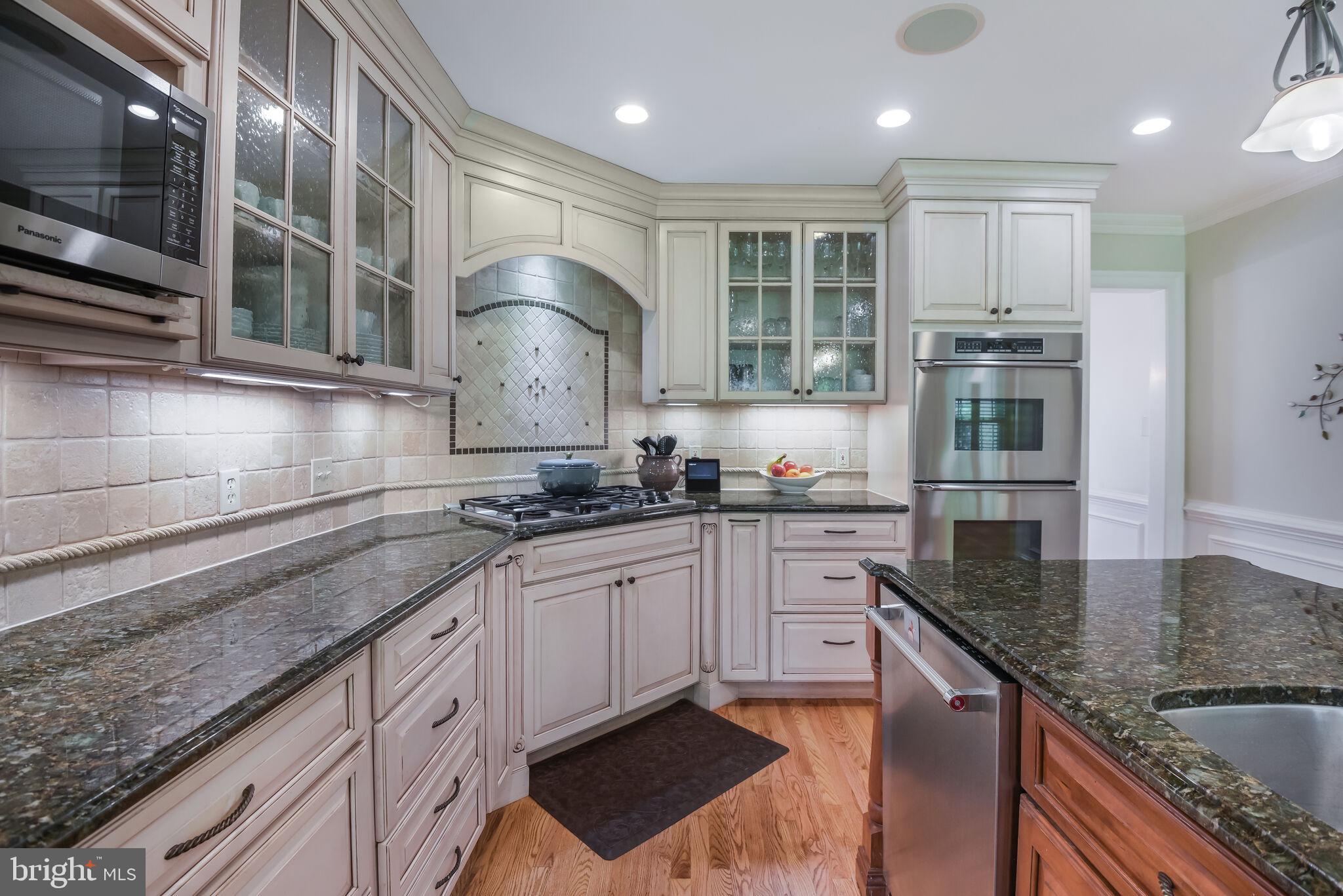 10601 Gainsborough Road Potomac, MD 20854 - Photo 21 of 55 a kitchen with granite countertop stainless steel appliances a sink stove and cabinets