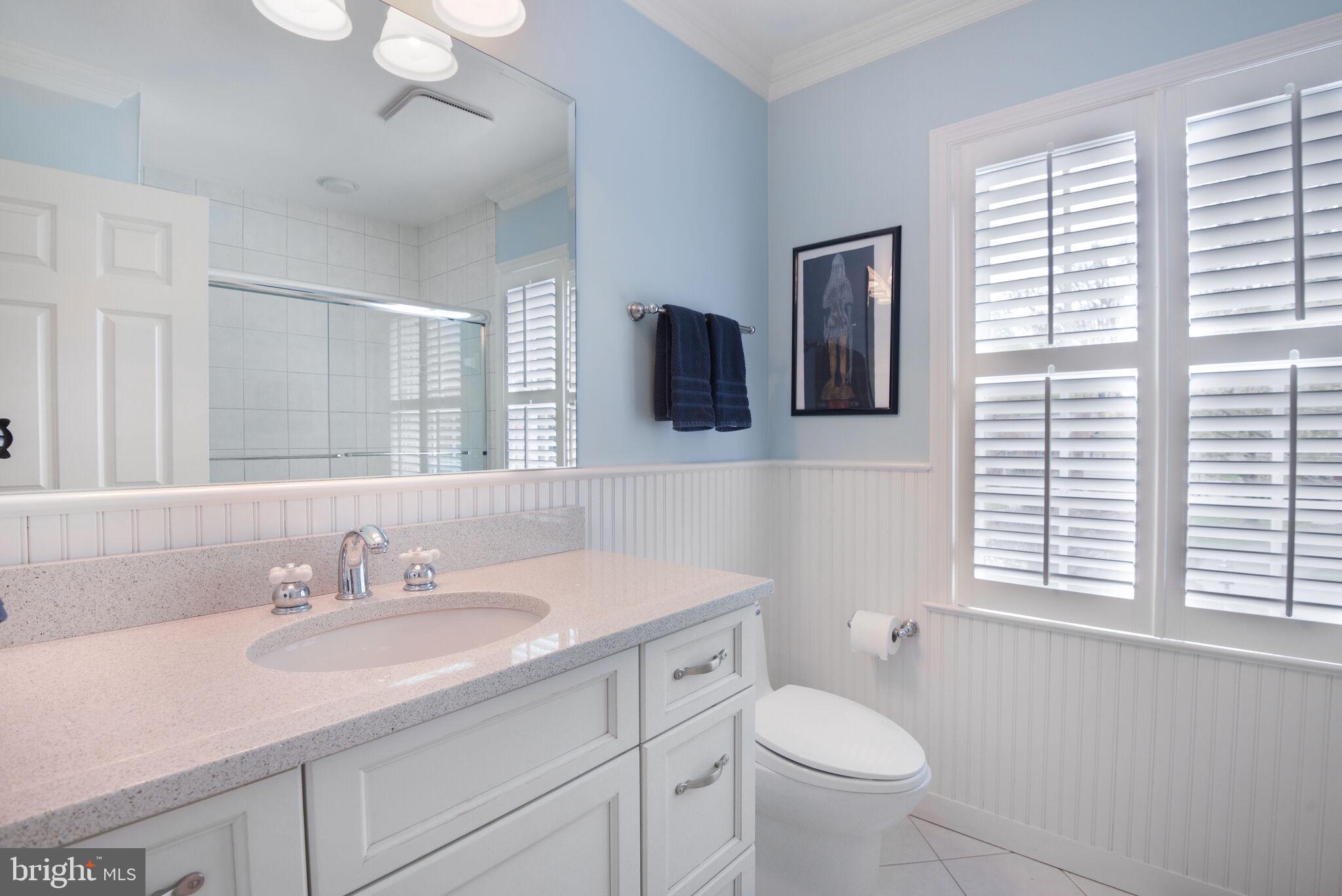 10601 Gainsborough Road Potomac, MD 20854 - Photo 40 of 55 a bathroom with a toilet a sink a mirror a window and vanity