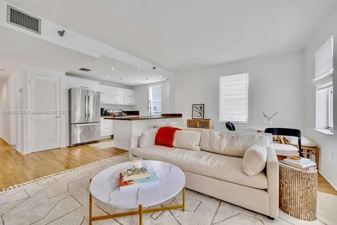 a living room with furniture and kitchen view