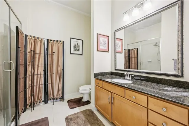 a bathroom with a granite countertop sink mirror vanity and toilet