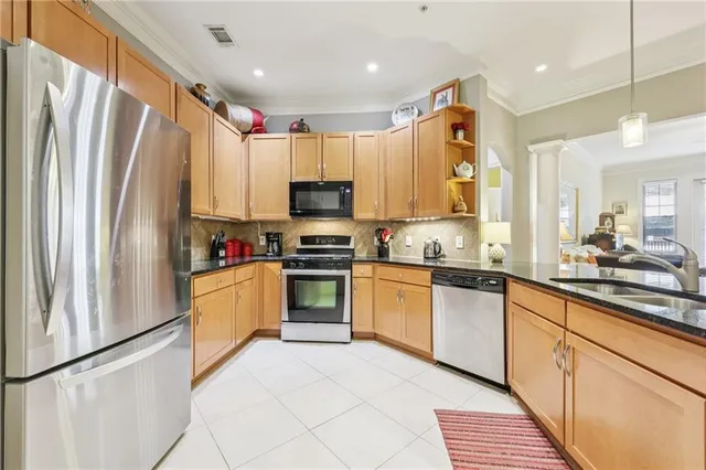 a kitchen with stainless steel appliances a refrigerator sink and microwave