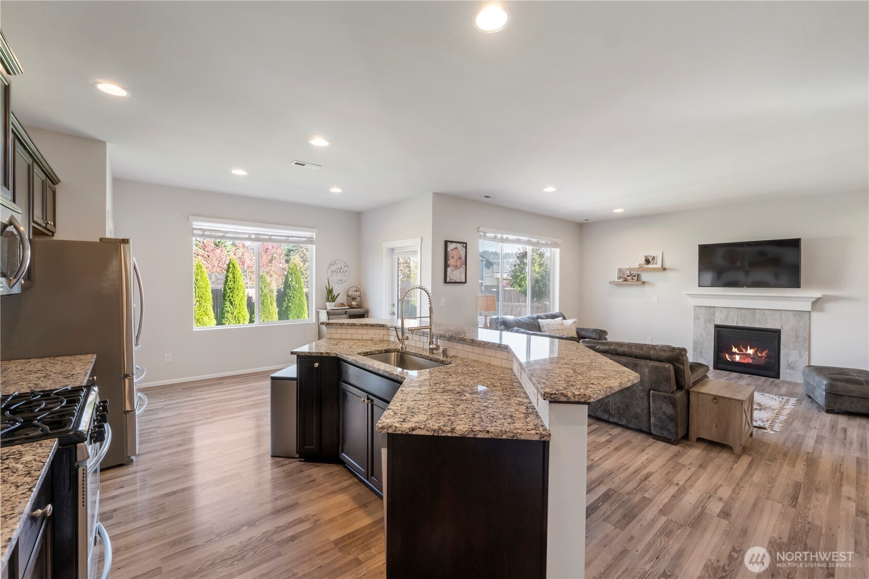 1002 O O'Farrell Lane Northwest Orting, WA 98360 - Photo 12 of 38 a living room with stainless steel appliances granite countertop furniture wooden floor and a fireplace