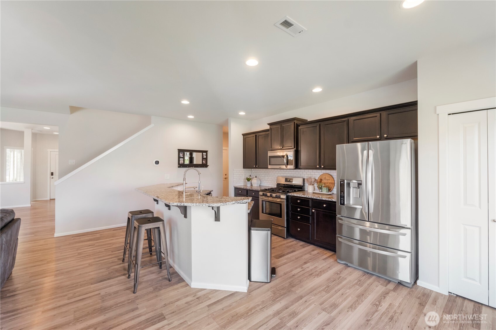1002 O O'Farrell Lane Northwest Orting, WA 98360 - Photo 14 of 38 a kitchen with kitchen island wooden floors appliances and cabinets