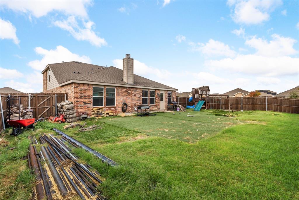 1014 Rio Frio Drive Forney, TX 75126 - Photo 19 of 19 Rear view of property with a chimney, a playground, brick siding, and a fenced backyard