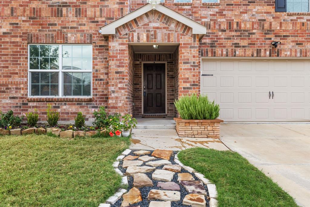 1014 Rio Frio Drive Forney, TX 75126 - Photo 2 of 19 Entrance to property featuring brick siding, concrete driveway, and a lawn