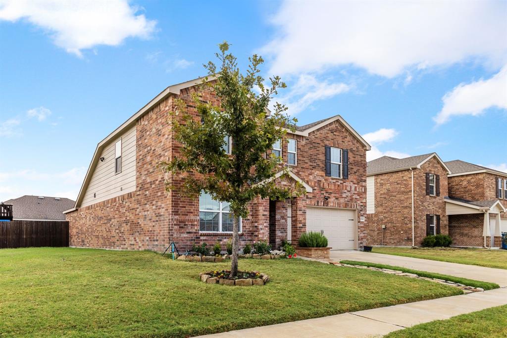 1014 Rio Frio Drive Forney, TX 75126 - Photo 3 of 19 View of front of home featuring driveway, brick siding, a front yard, and an attached garage
