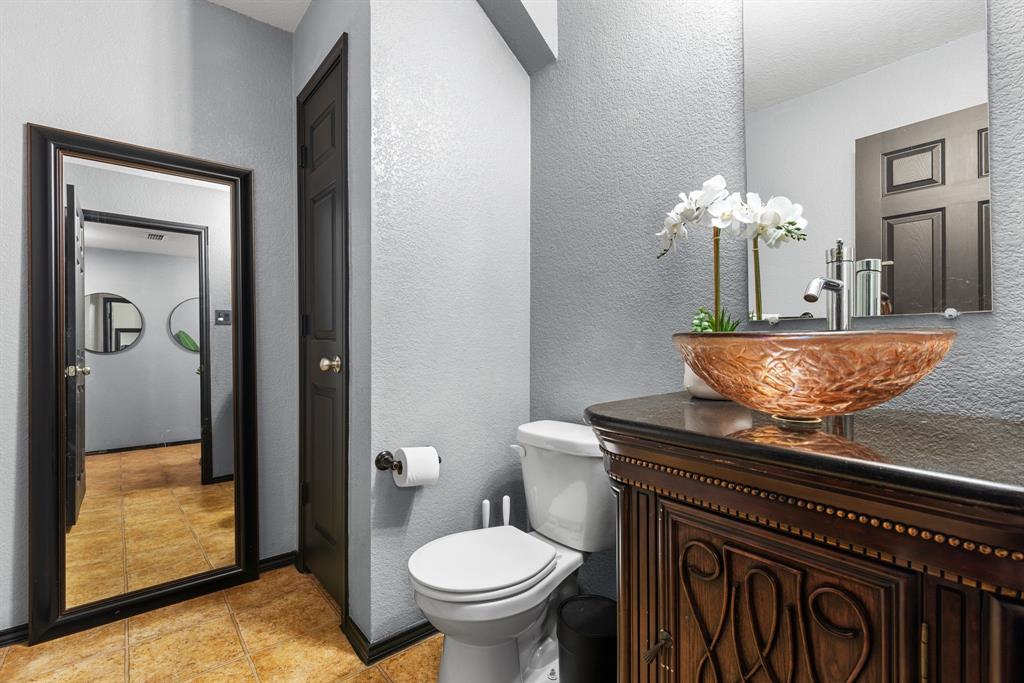 1014 Rio Frio Drive Forney, TX 75126 - Photo 8 of 19 Half bathroom with a textured wall, vanity, and light tile patterned floors