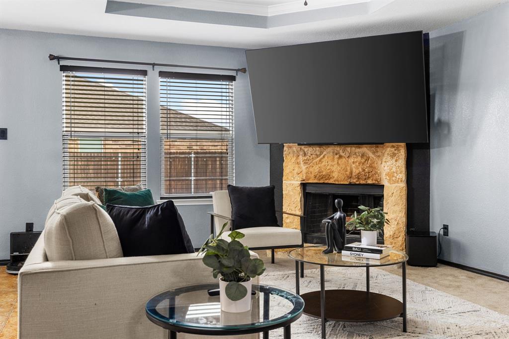 1014 Rio Frio Drive Forney, TX 75126 - Photo 10 of 19 Carpeted living area with a fireplace and a raised ceiling