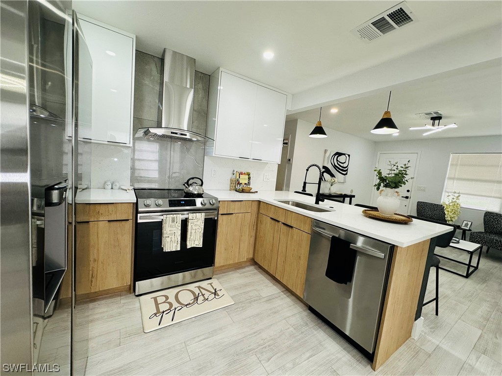2926 Holly Road Fort Myers, FL 33901 - Photo 14 of 47 a kitchen with a sink stainless steel appliances and cabinets