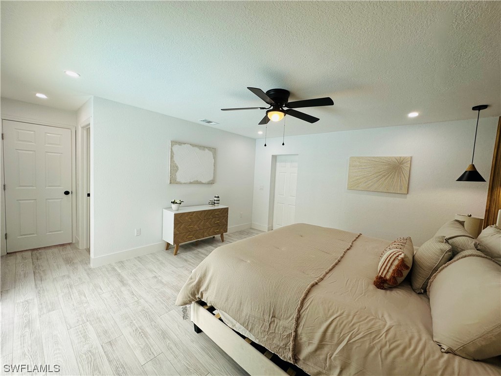 2926 Holly Road Fort Myers, FL 33901 - Photo 34 of 47 a bedroom with a bed and a chandelier