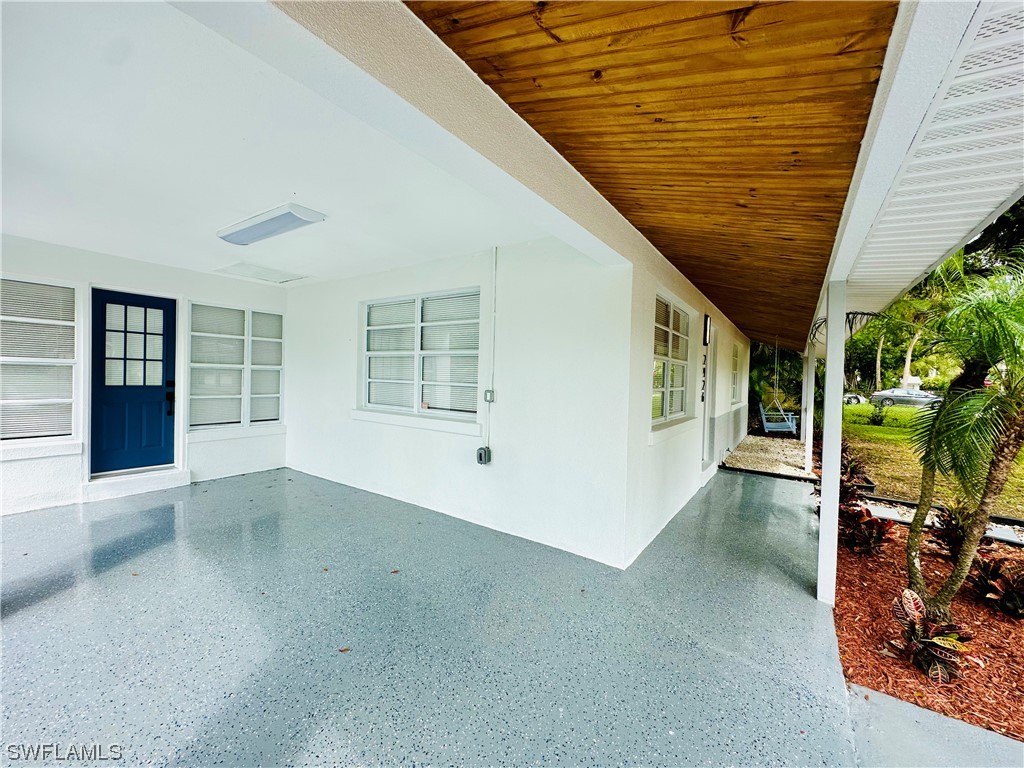 2926 Holly Road Fort Myers, FL 33901 - Photo 7 of 47 an empty room with wooden floor and windows