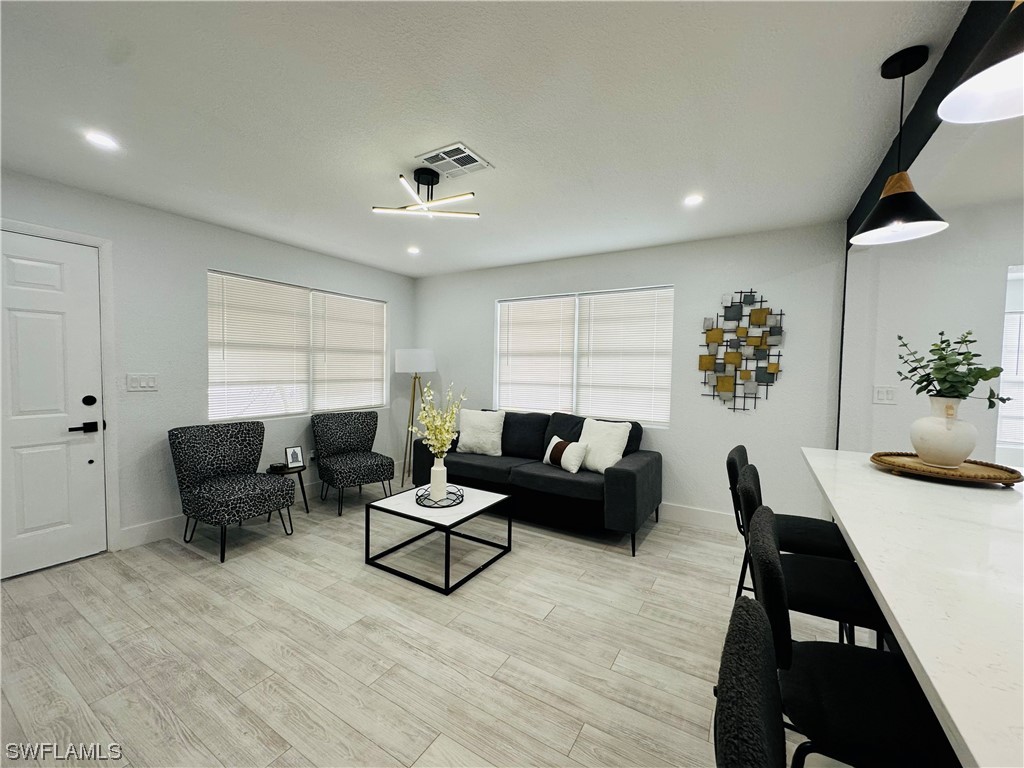 2926 Holly Road Fort Myers, FL 33901 - Photo 10 of 47 a living room with furniture and a wooden floor