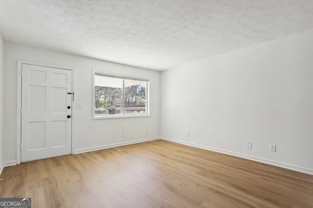 a view of an empty room with wooden floor