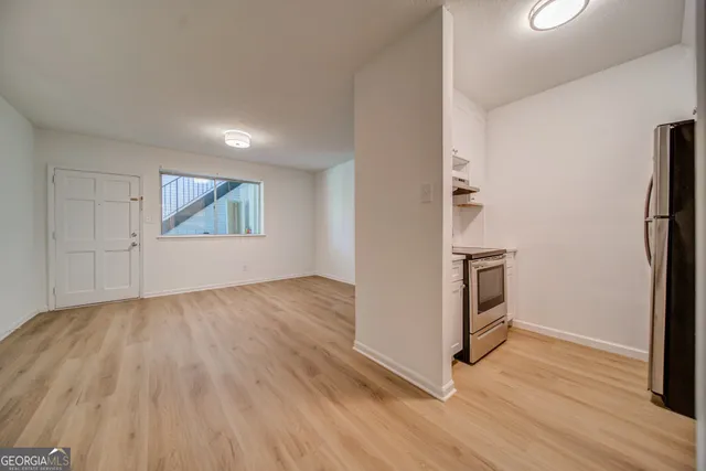 a view of a kitchen with wooden floor and electronic appliances