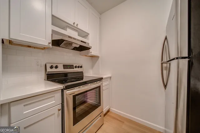 a view of a stove top oven and cabinets