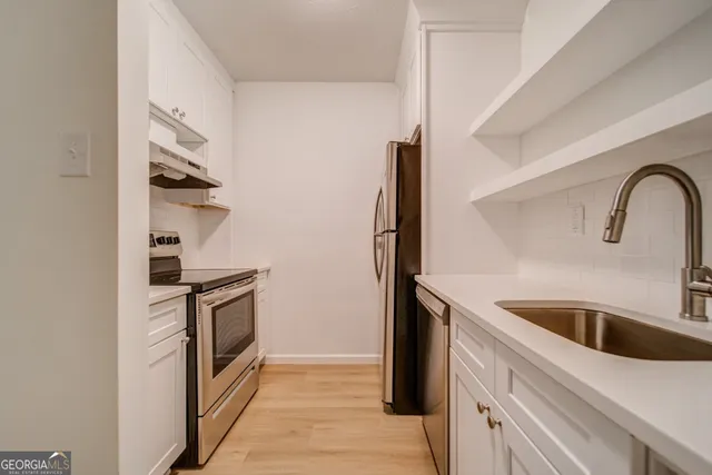 a kitchen with stainless steel appliances granite countertop a sink and a refrigerator