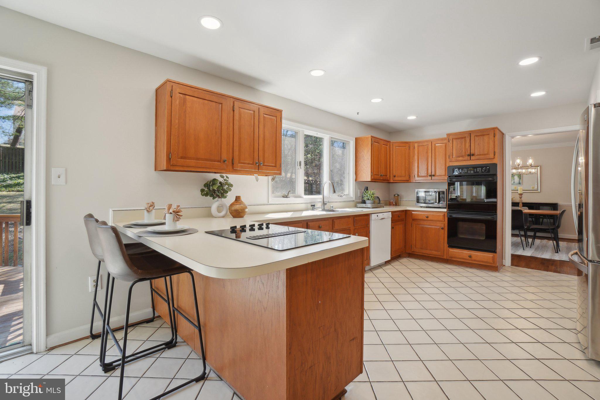15301 Watergate Road Silver Spring, MD 20905 - Photo 10 of 51 a kitchen with stainless steel appliances granite countertop a sink a stove a refrigerator and a dining table