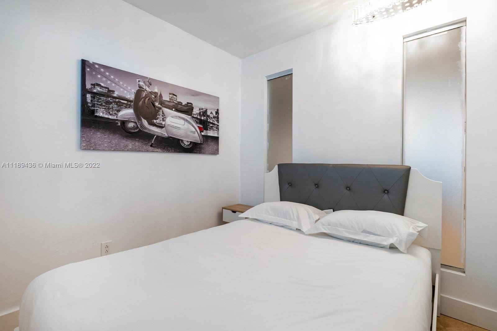 751 Collins Avenue, Unit 6 Miami Beach, FL 33139 - Photo 12 of 15 a bedroom with a bed and painting on the wall