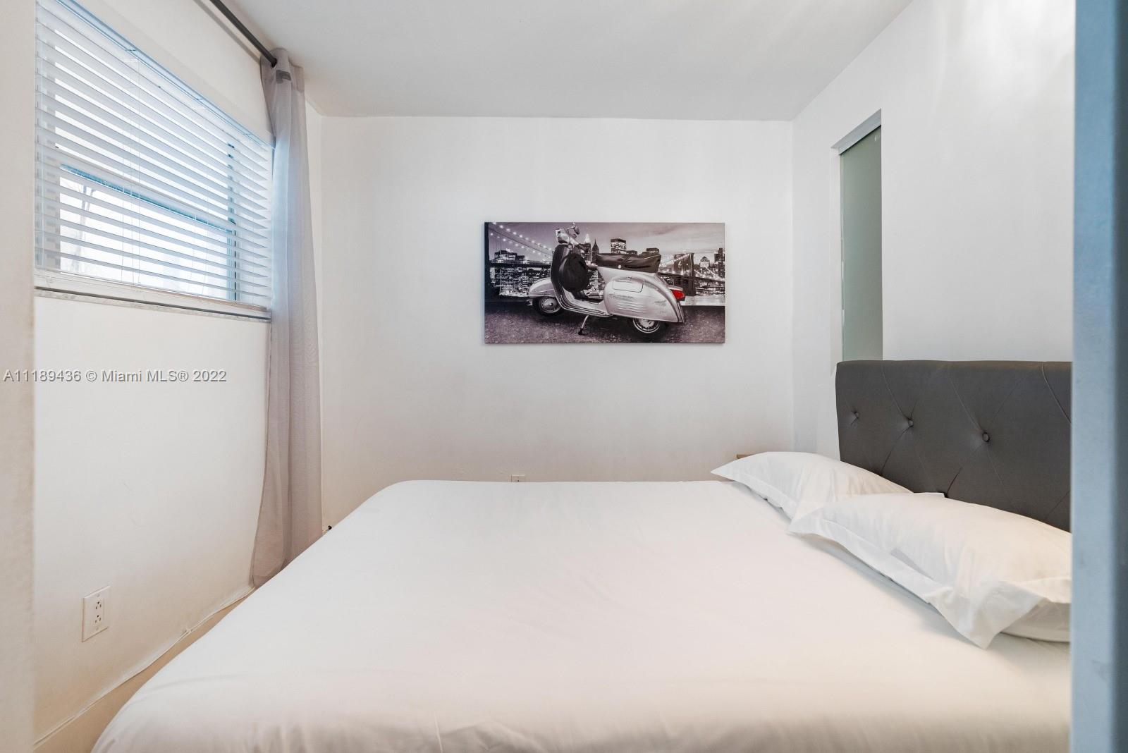 751 Collins Avenue, Unit 6 Miami Beach, FL 33139 - Photo 14 of 15 a bedroom with a bed and wall painting