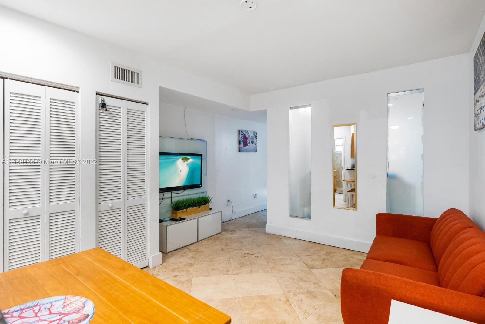 751 Collins Avenue, Unit 6 Miami Beach, FL 33139 - Photo 4 of 15 a bedroom with furniture and a flat screen tv