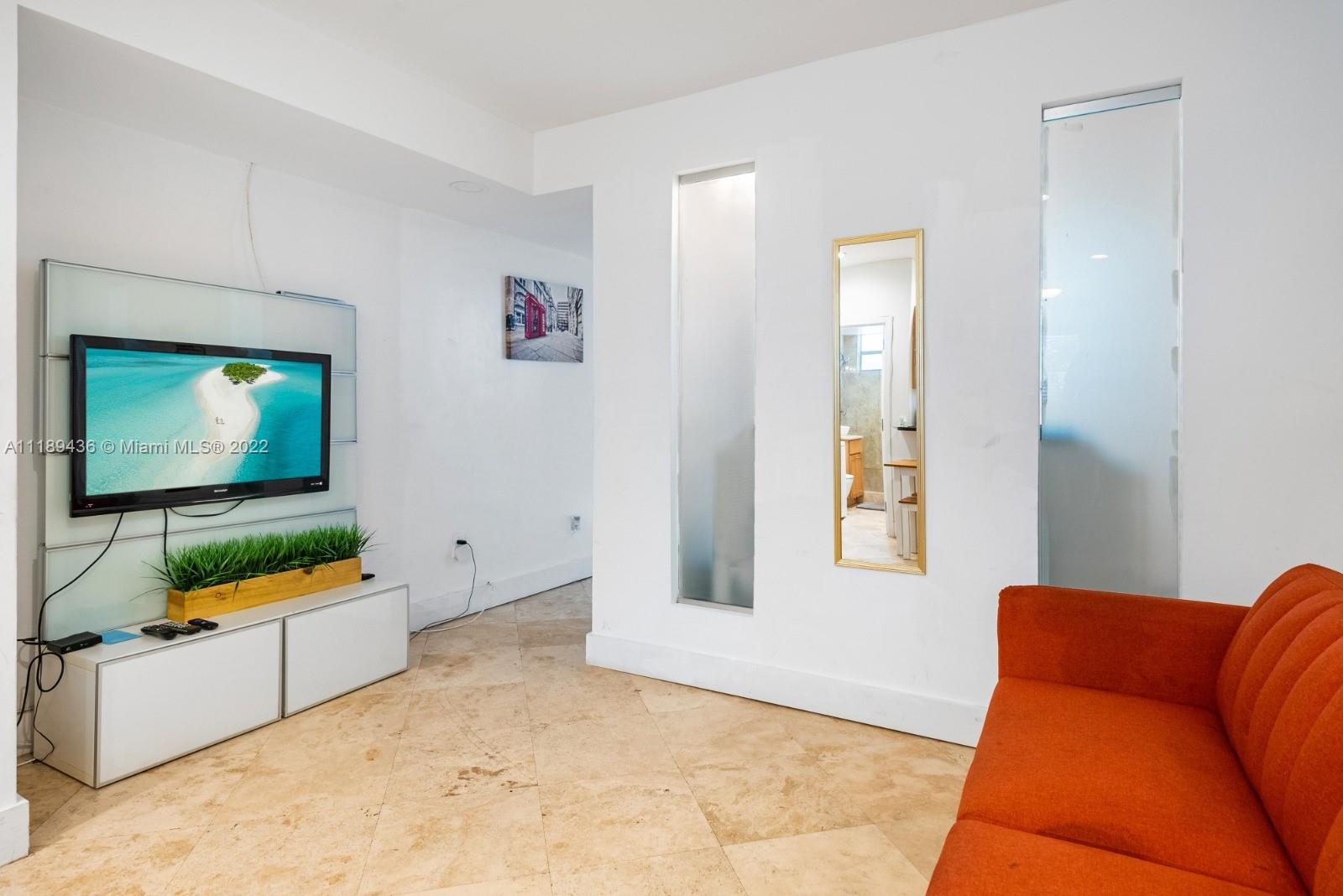 751 Collins Avenue, Unit 6 Miami Beach, FL 33139 - Photo 5 of 15 a living room with furniture and a flat screen tv