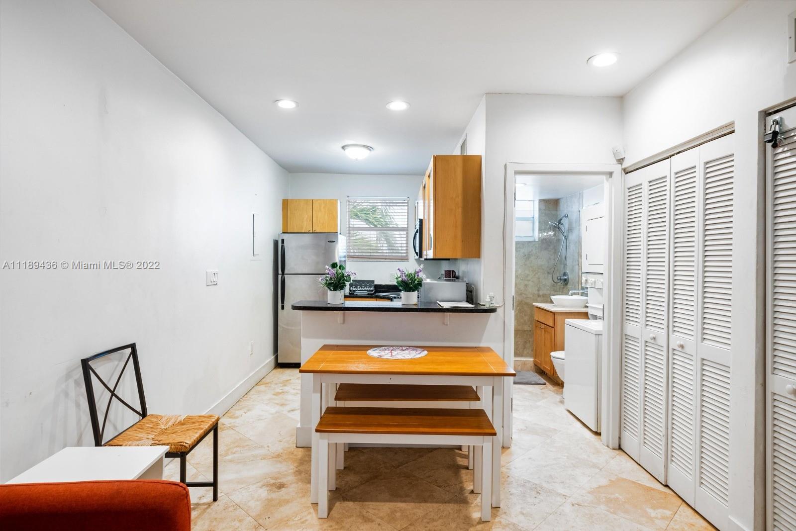 751 Collins Avenue, Unit 6 Miami Beach, FL 33139 - Photo 7 of 15 a view of a kitchen with kitchen island dining table and chairs