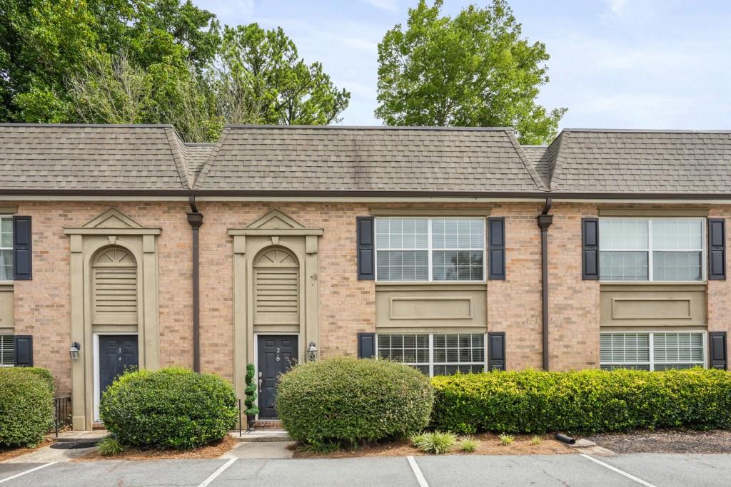 6980 Roswell Road, Unit H2 Sandy Springs, GA 30328 - Photo 1 of 1 a front view of a house with plants
