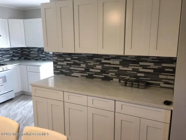 a kitchen with white cabinets and sink