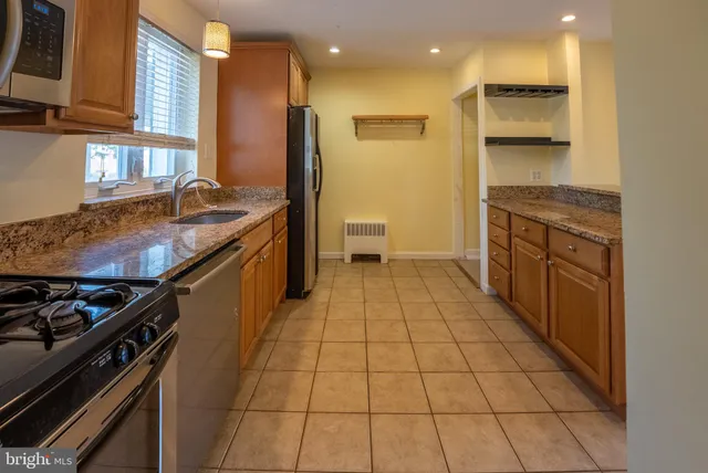 a kitchen with stainless steel appliances granite countertop a stove and a refrigerator