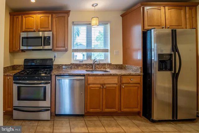 a kitchen with stainless steel appliances granite countertop a refrigerator stove and sink