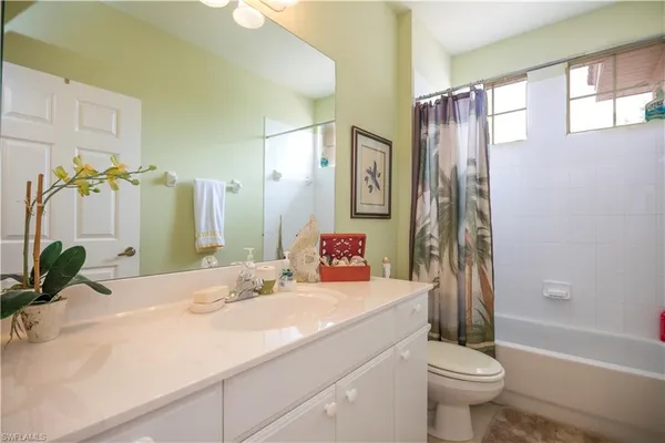 a bathroom with a sink a toilet and a large mirror