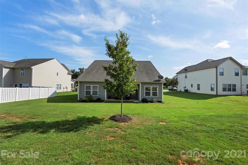 8098 Bryson Road Indian Land, SC 29707 - Photo 23 of 30 a house that is sitting in the grass with large trees and plants