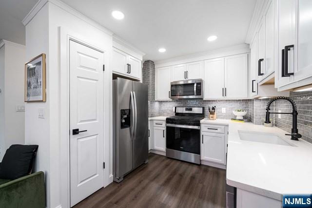 141 Park Avenue, Unit 8A East Rutherford, NJ 07073 - Photo 8 of 22 a kitchen with stainless steel appliances and wooden cabinets