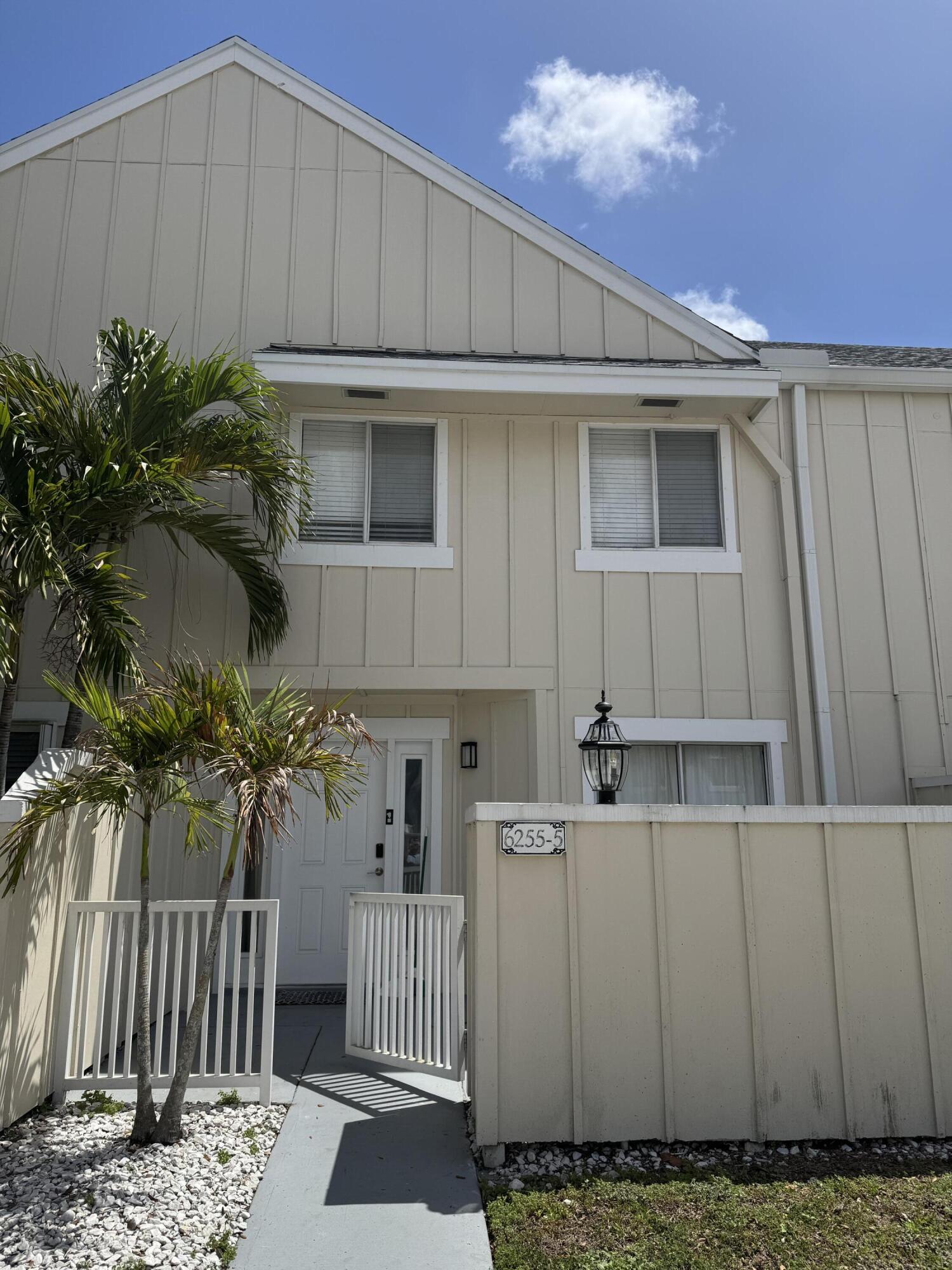 a view of a house with a wooden fence