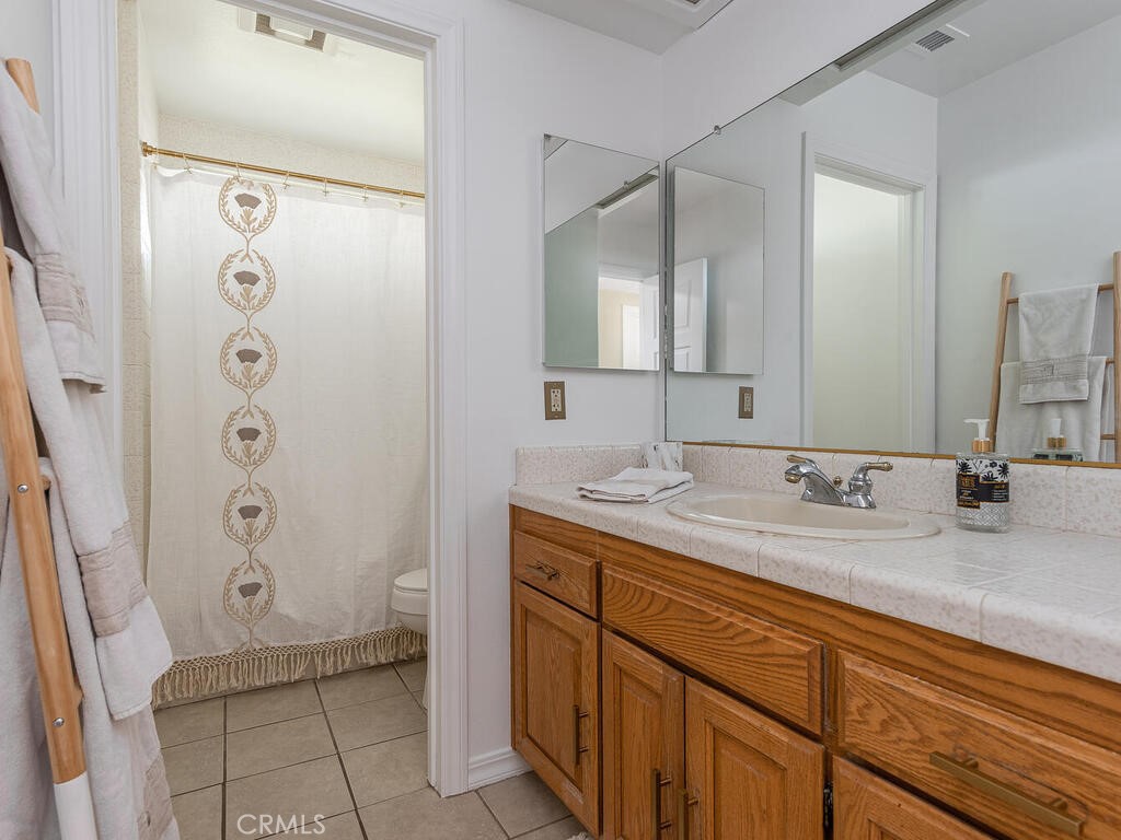 7790 Airport Road Paso Robles, CA 93446 - Photo 56 of 71 a bathroom with a granite countertop sink a mirror and a shower