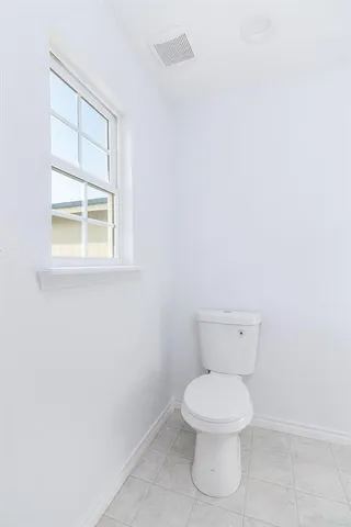 a white toilet sitting next to a window