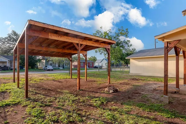 a backyard of a house with table and chairs