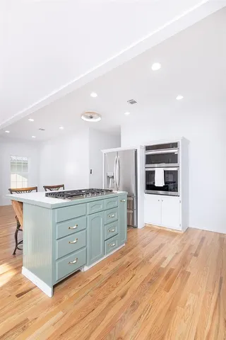 a kitchen with stainless steel appliances kitchen island granite countertop a sink and cabinets