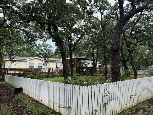 a view of a house with a small yard and wooden fence