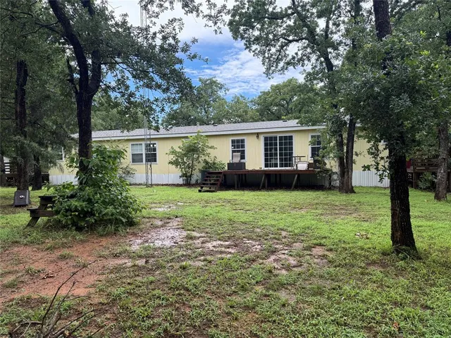a view of backyard of house with green space