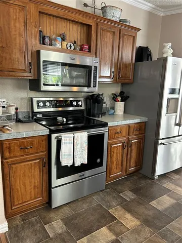a kitchen with stainless steel appliances granite countertop a stove microwave and refrigerator