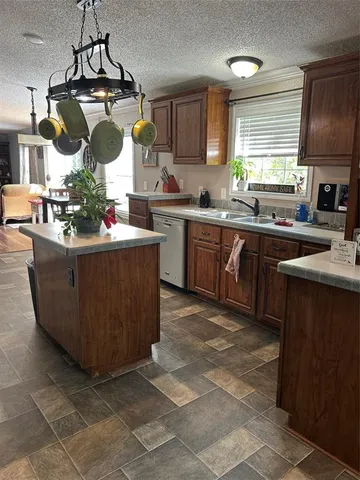 a kitchen with stainless steel appliances granite countertop a sink counter space cabinets and a window