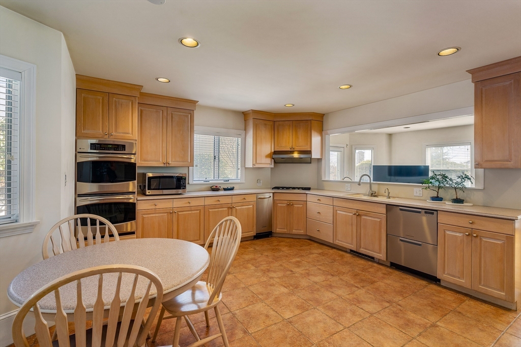 10 Redstone Lane Marblehead, MA 01945 - Photo 14 of 31 a kitchen with stainless steel appliances granite countertop a sink a stove a refrigerator cabinets a dining table and chairs