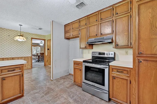 a kitchen with stainless steel appliances granite countertop a stove and a refrigerator