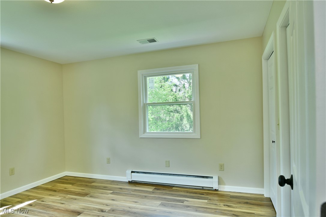 2153 Stillwagon Road Southeast Warren, OH 44484 - Photo 34 of 50 Empty room with baseboard heating, wood finished floors, and baseboards