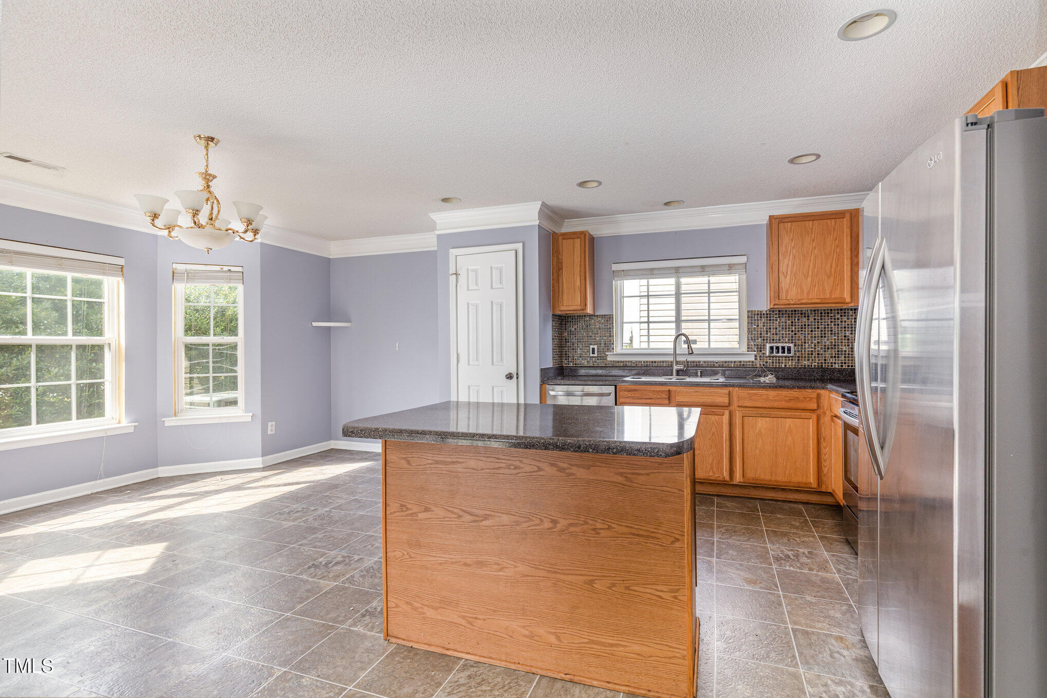 2640 Quarry Springs Road Raleigh, NC 27610 - Photo 5 of 31 a large kitchen with kitchen island granite countertop a large counter top stainless steel appliances a window and cabinets