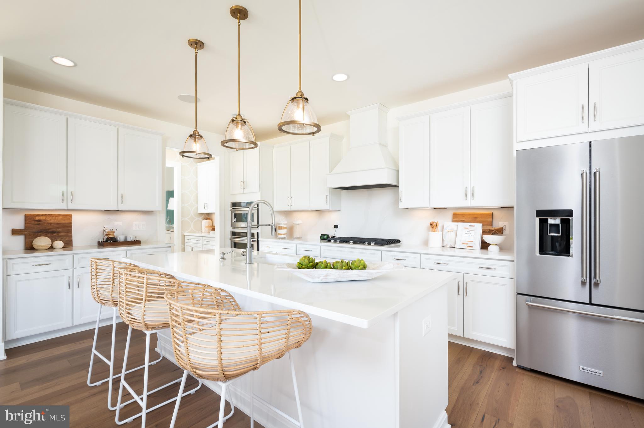 42108 Creighton Road Ashburn, VA 20148 - Photo 13 of 39 a kitchen with stainless steel appliances kitchen island granite countertop a refrigerator a stove a white table and chairs with wooden floors