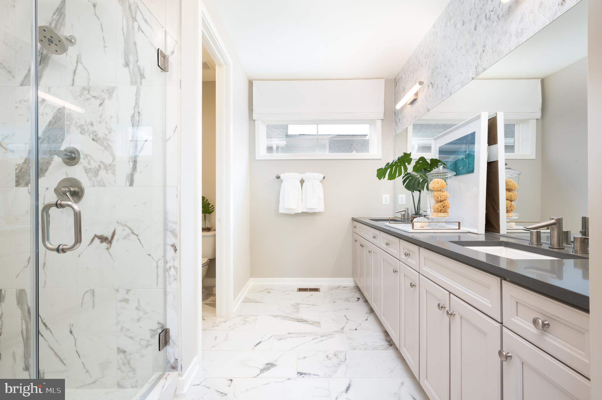 42108 Creighton Road Ashburn, VA 20148 - Photo 25 of 39 a spacious bathroom with a granite countertop sink a mirror and shower