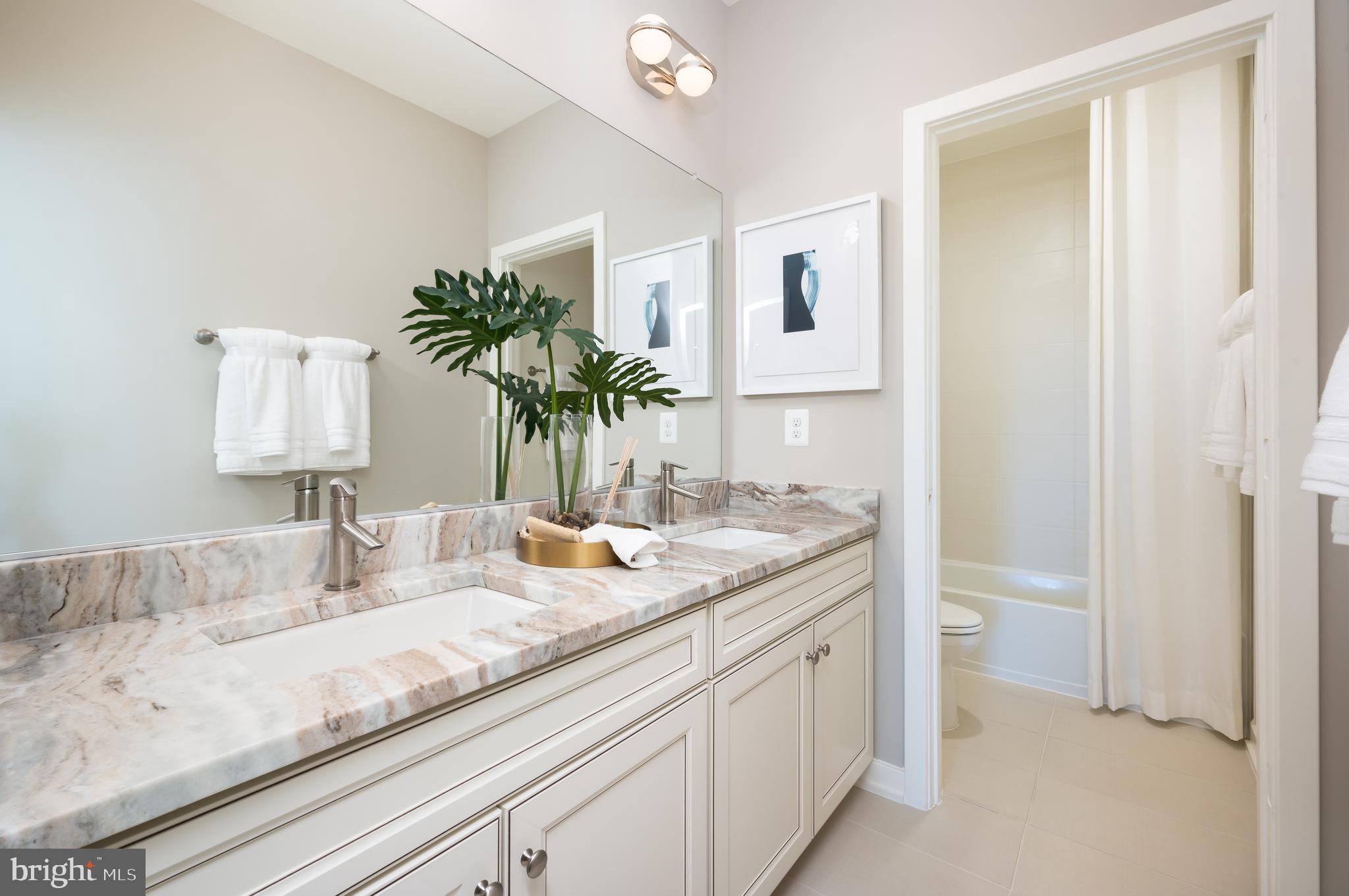 42108 Creighton Road Ashburn, VA 20148 - Photo 32 of 39 a bathroom with a granite countertop sink and a mirror