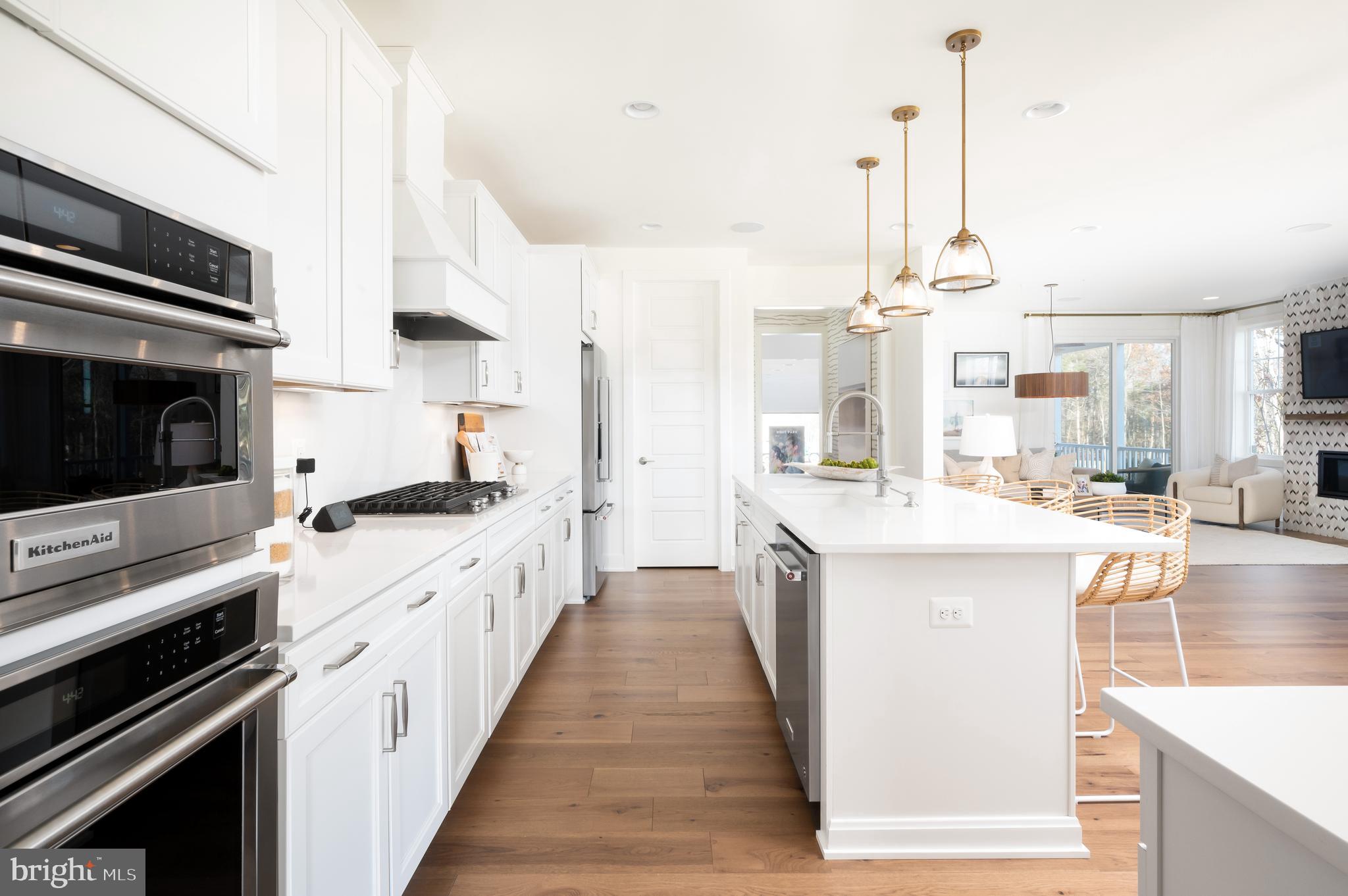 42108 Creighton Road Ashburn, VA 20148 - Photo 9 of 39 a large kitchen with stainless steel appliances kitchen island granite countertop a sink and cabinets